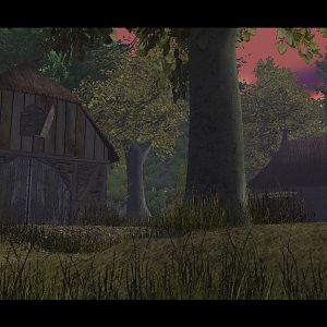 A barn is visible while peaking over the tall grasses with a cute farm house in the background.