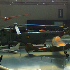 Far view of a Sikorsky SH-3 Sea King Helicopter, and perhaps a Cessna.